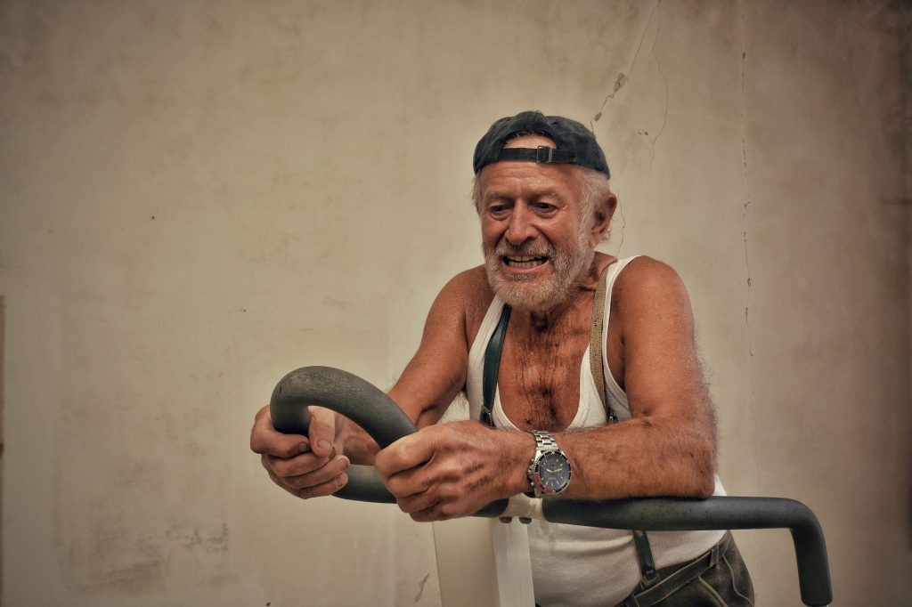 Meilleur vélo d'appartement pour senior — senior utilisant un vélo d'appartement